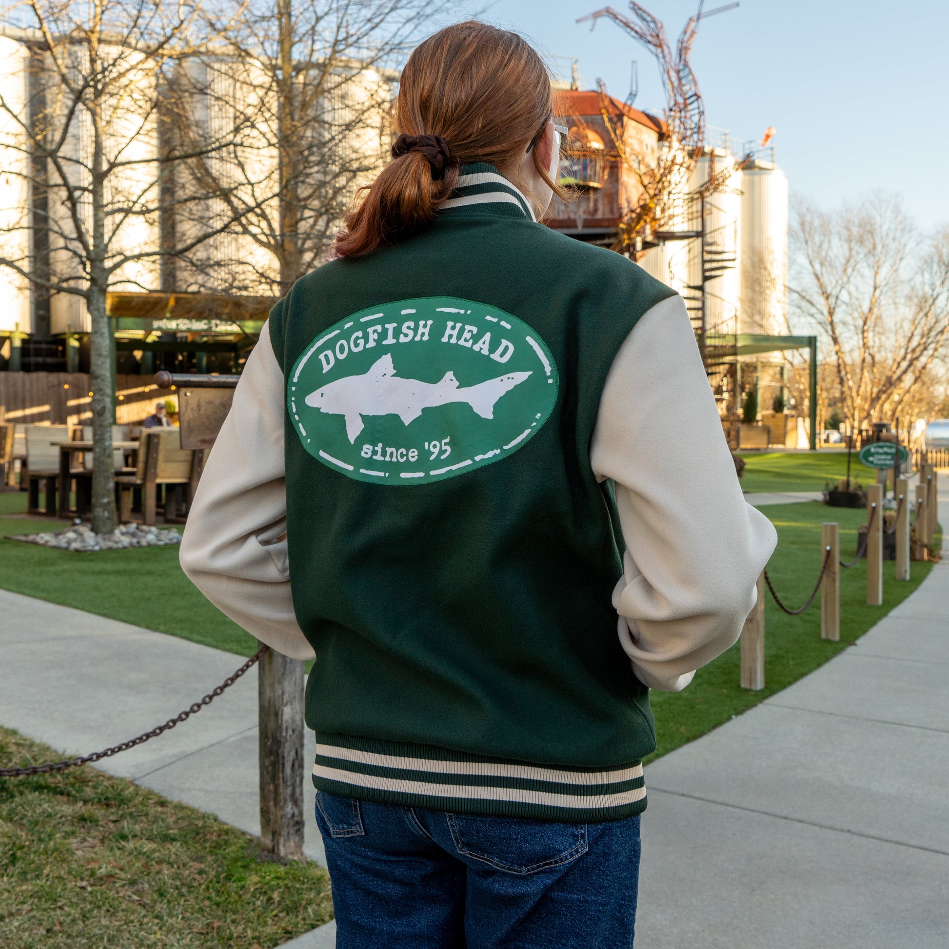 Person wearing a green and white 'Dogfish Head' jacket outdoors.