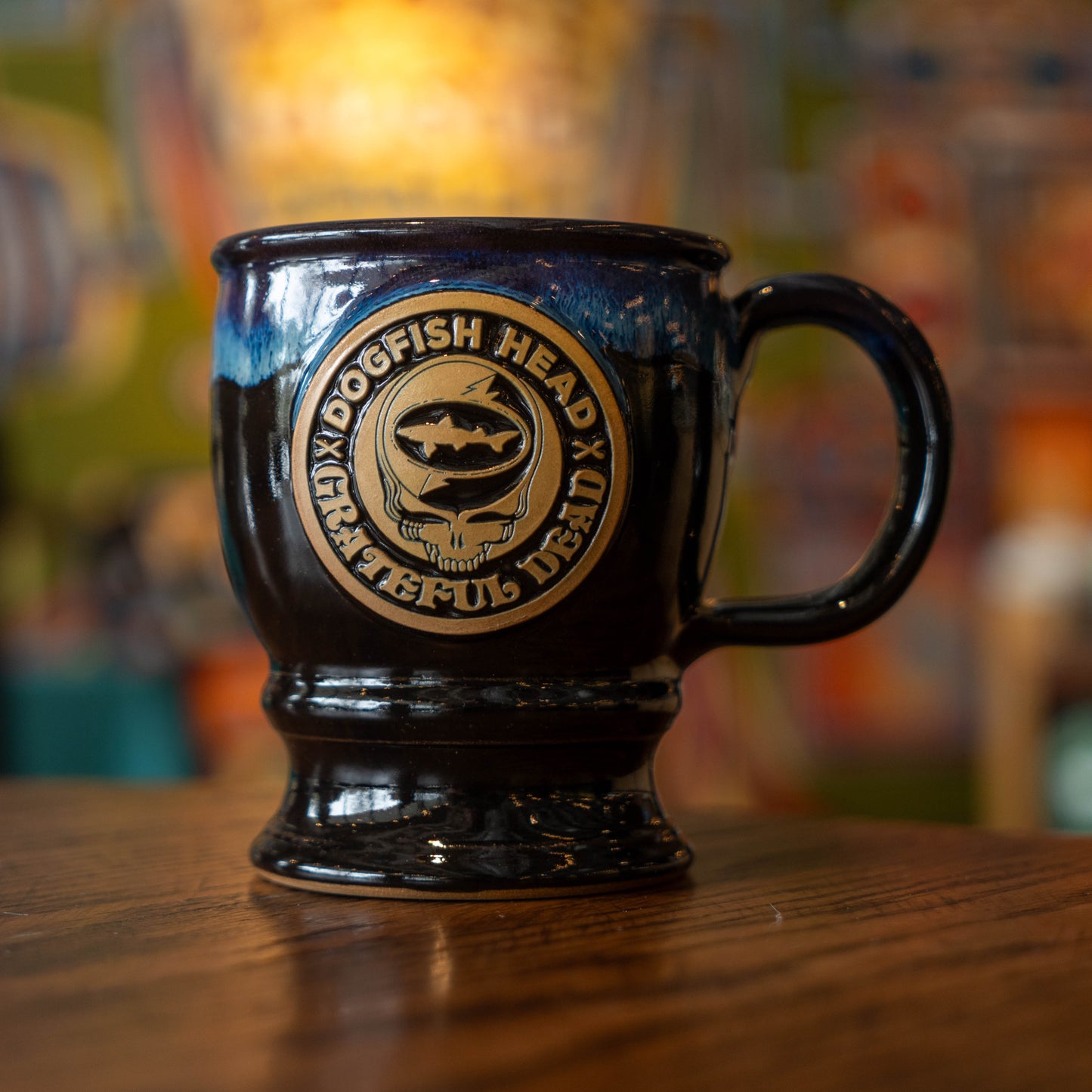 Black and blue ceramic mug with a brown Dogfish Head x Grateful Dead logo.