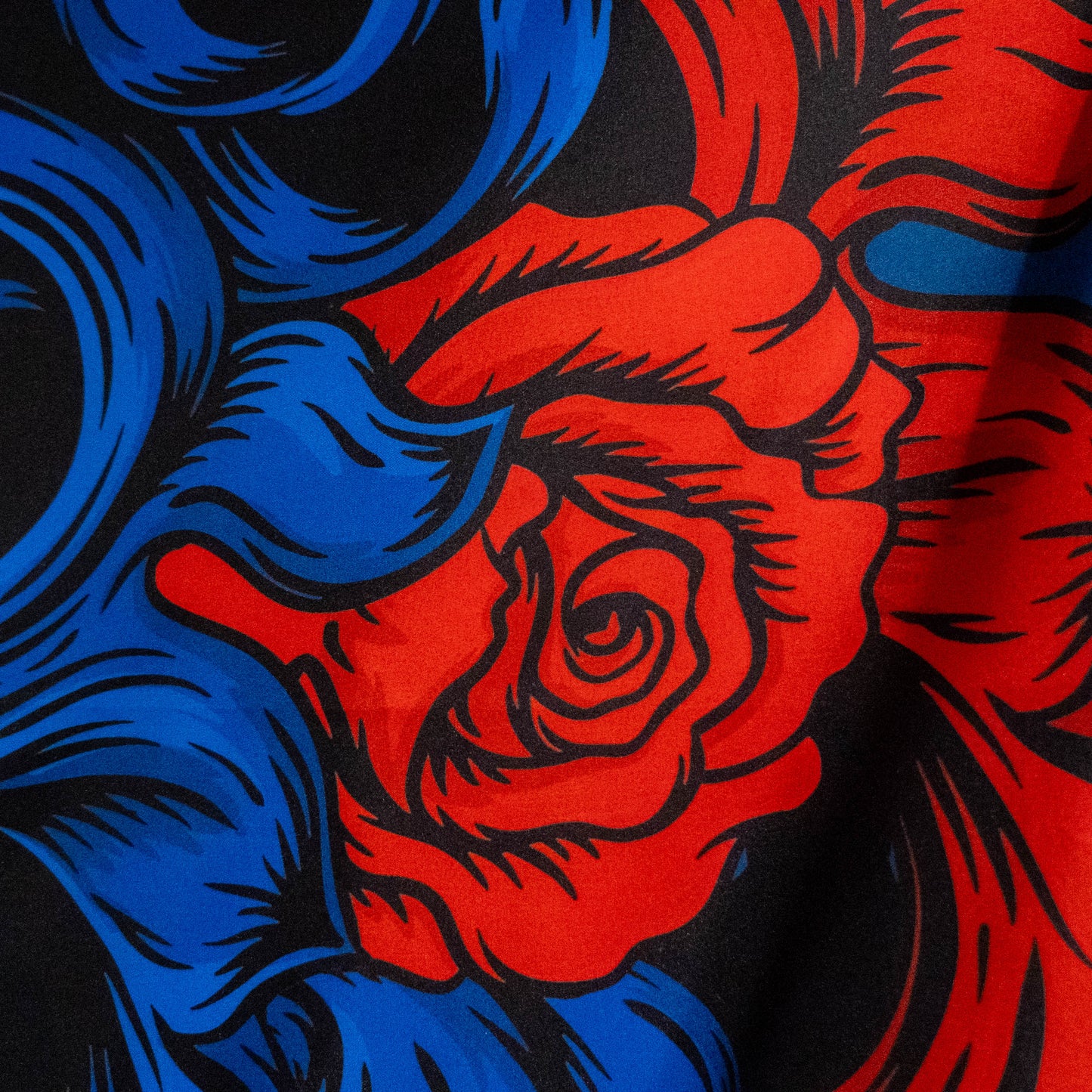 Close-up of a red rose with blue and black abstract patterns on a dark background