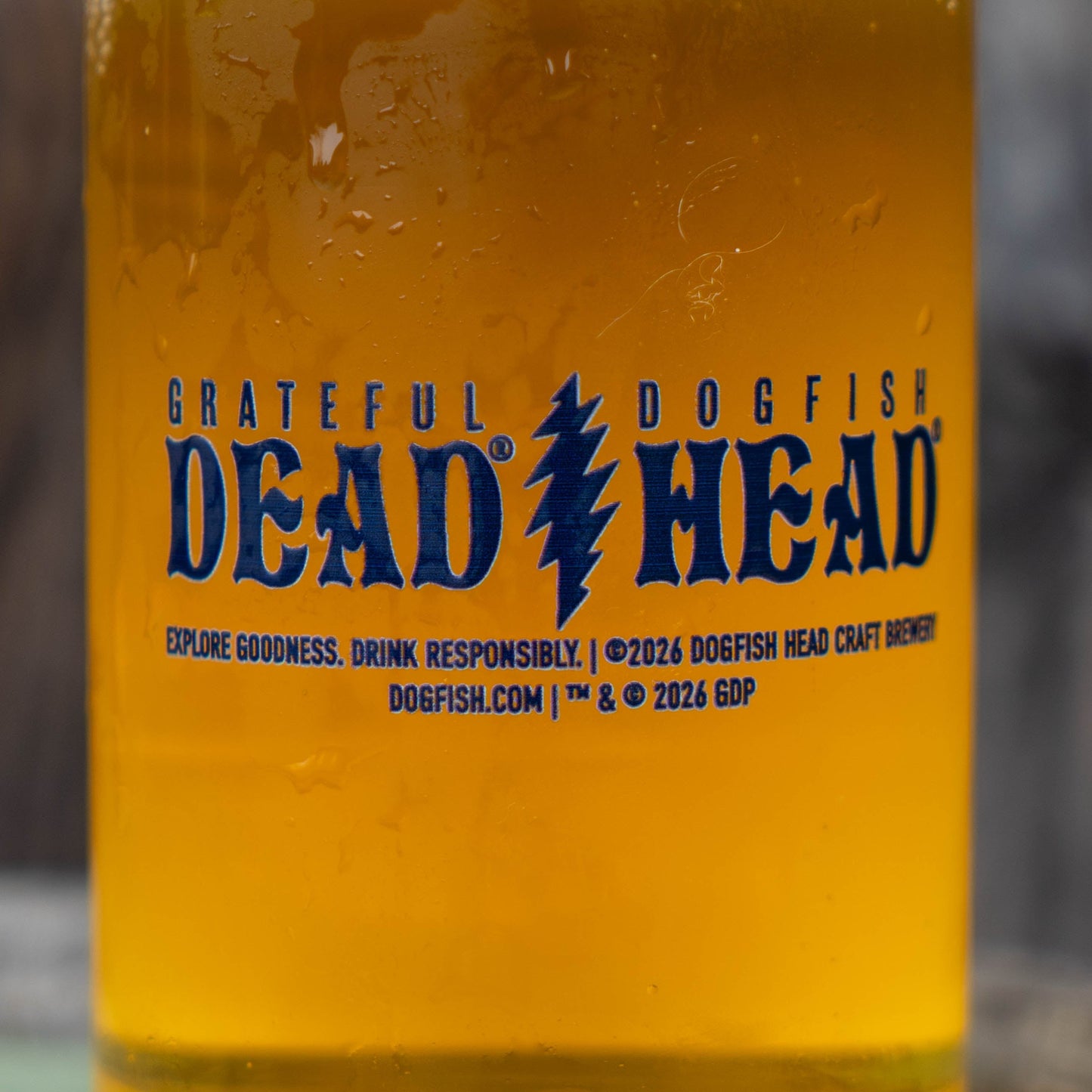 Close-up of navy Grateful Dead x Dogfish Head logo printed on clear 2026 Record Store Day can glass filled with golden beer.