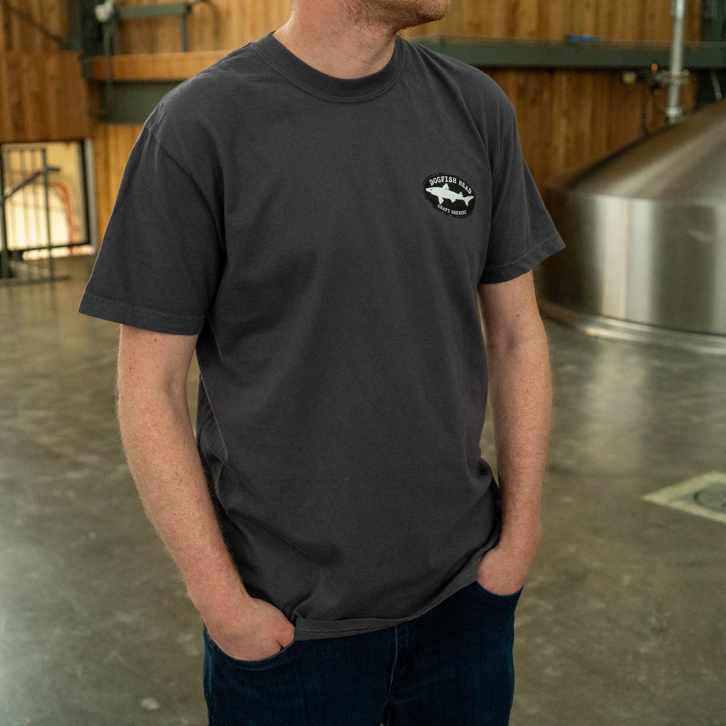 Front three‑quarter view of a graphite gray Dogfish Head T‑shirt showing relaxed fit and short sleeves.