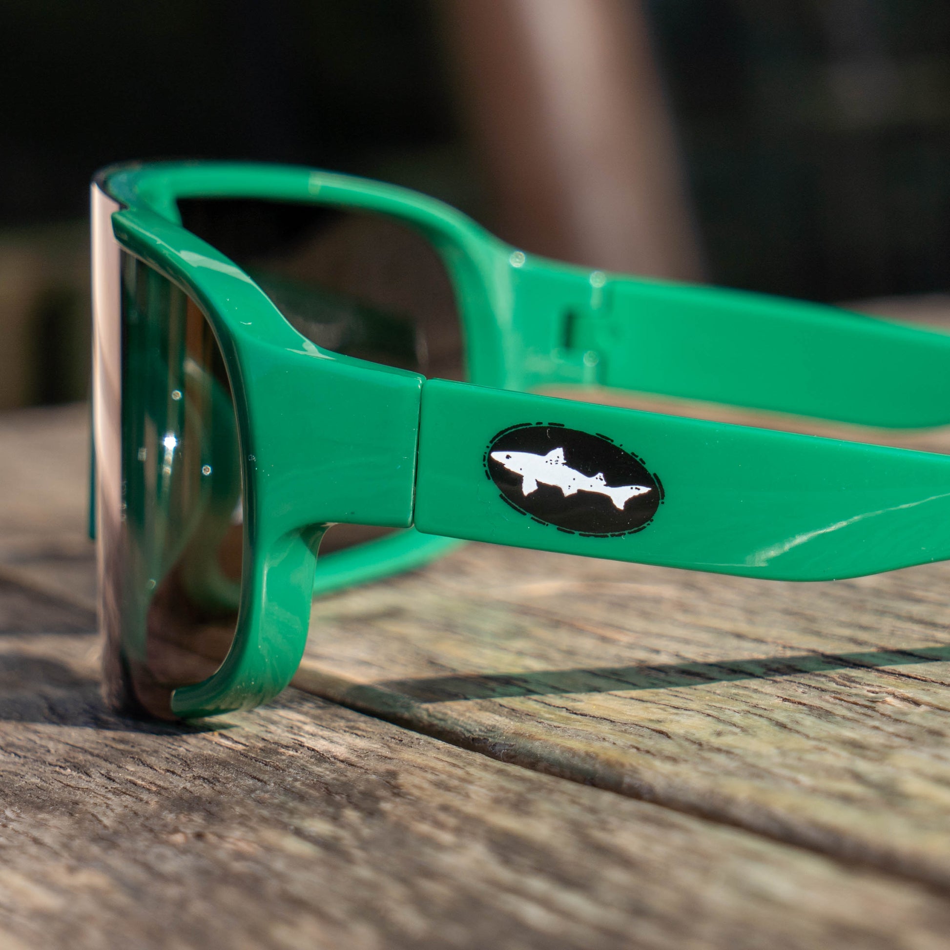 Close up Green Dogfish Head Polarized Sunglasses, showing a small black dogfish head logo on the left arm