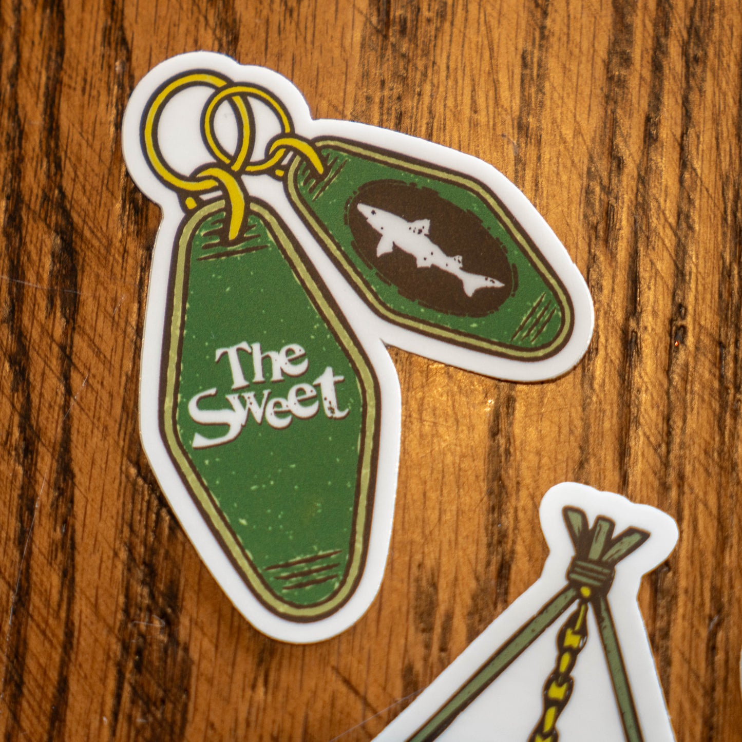 Green keychain with two diamond shape tags (one reads "The Sweet", the other has a dogfish head logo) sticker