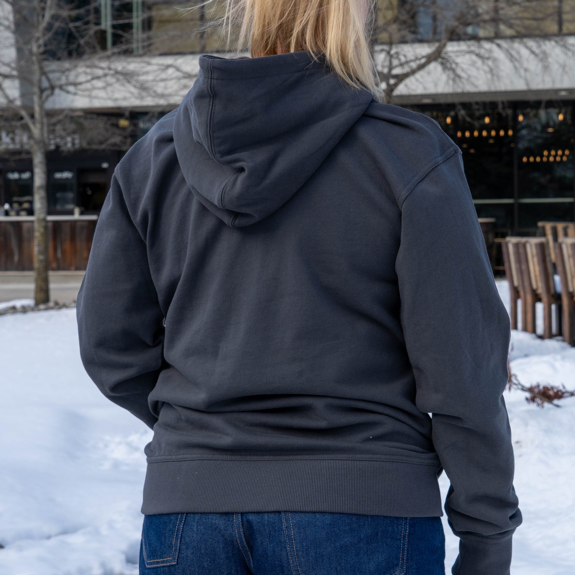 Backside of a woman wearing a onyx black delaware hoodie 