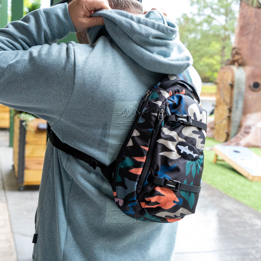 Patagonia Black Atom Sling 8L crossbody sling bag in camo print worn outdoors, lightweight everyday carry bag for travel and hiking