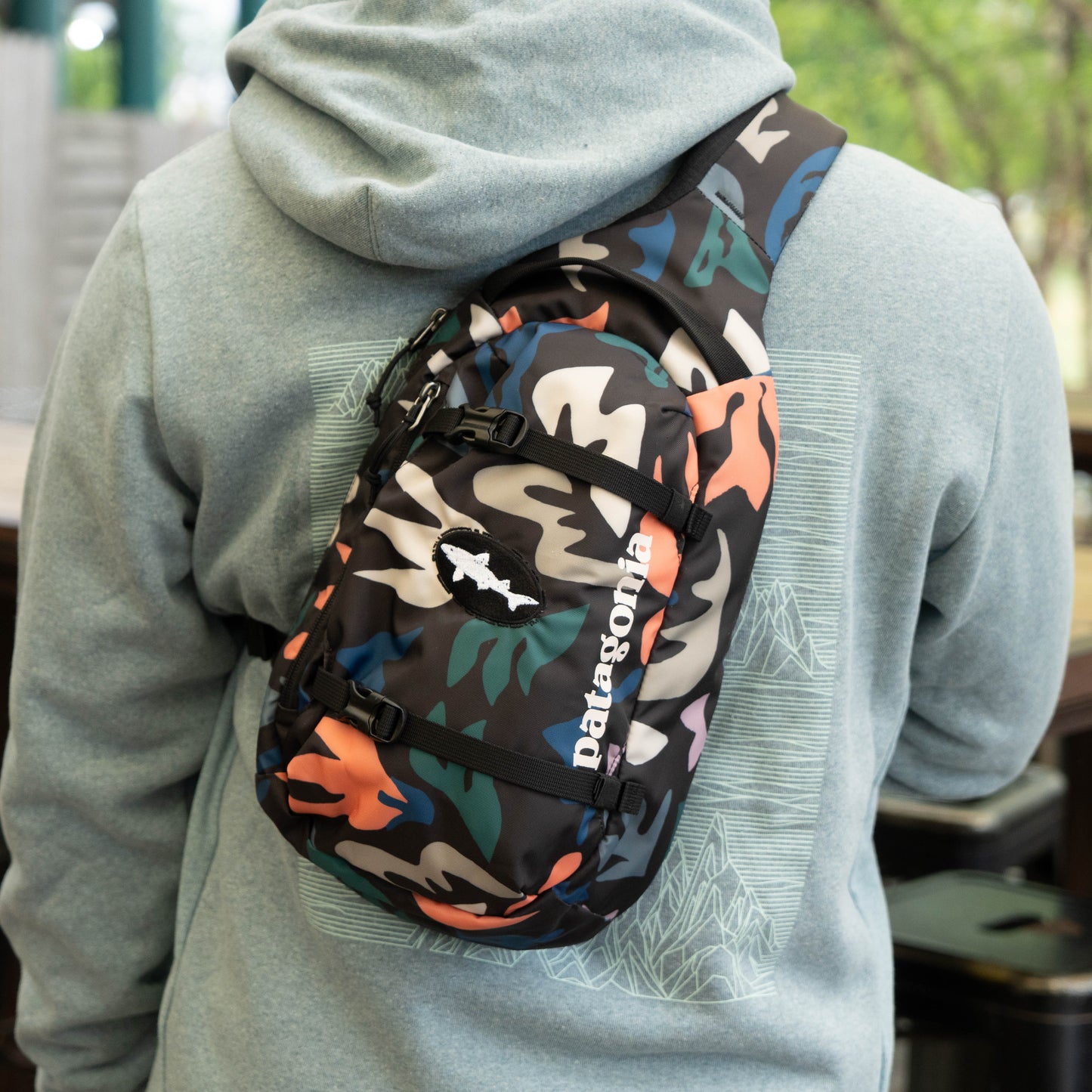 Close-up of Patagonia Black Atom Sling 8L camo sling backpack with adjustable strap and zipper pockets, ergonomic crossbody design