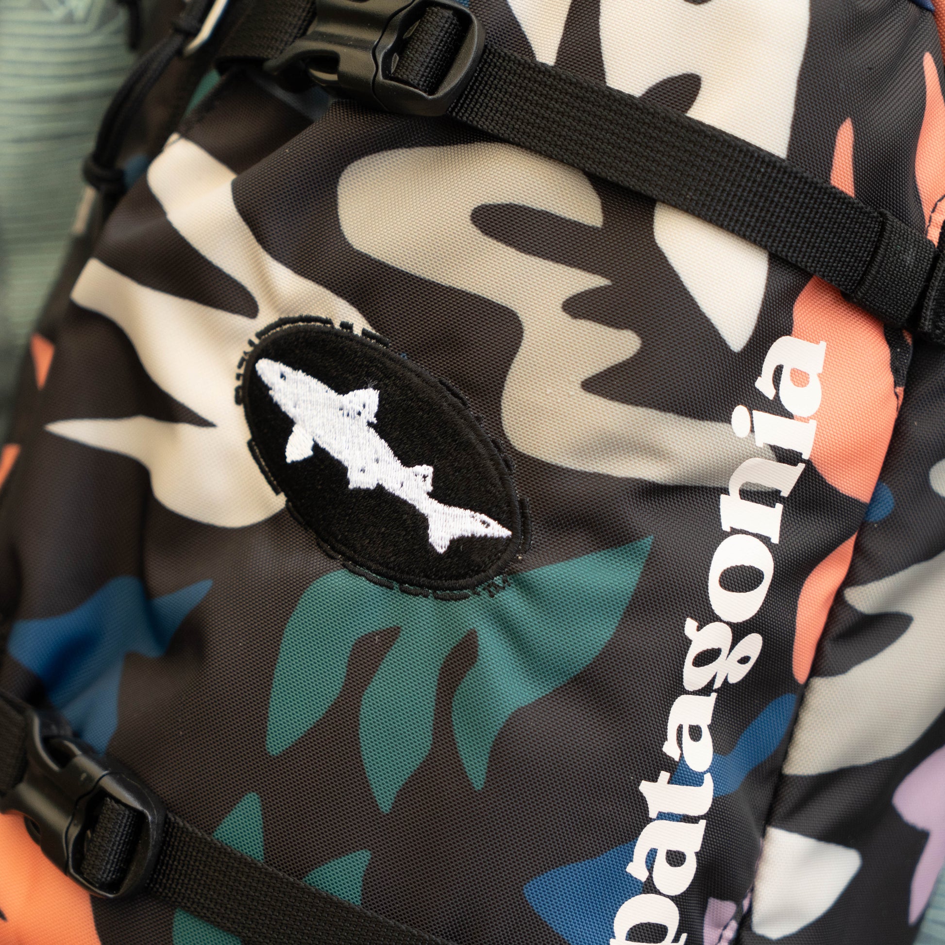 Detailed view of Patagonia Atom Sling 8L camo print fabric with logo patch and durable material, compact outdoor daypack