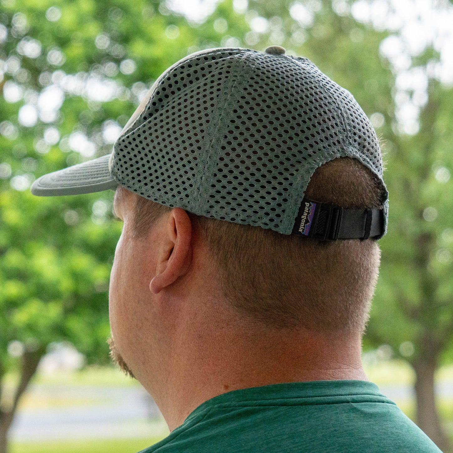 Side view of a man wearing Patagonia Spoonbill trucker hat with breathable mesh panels and adjustable strap, and a Patagonia branded tag