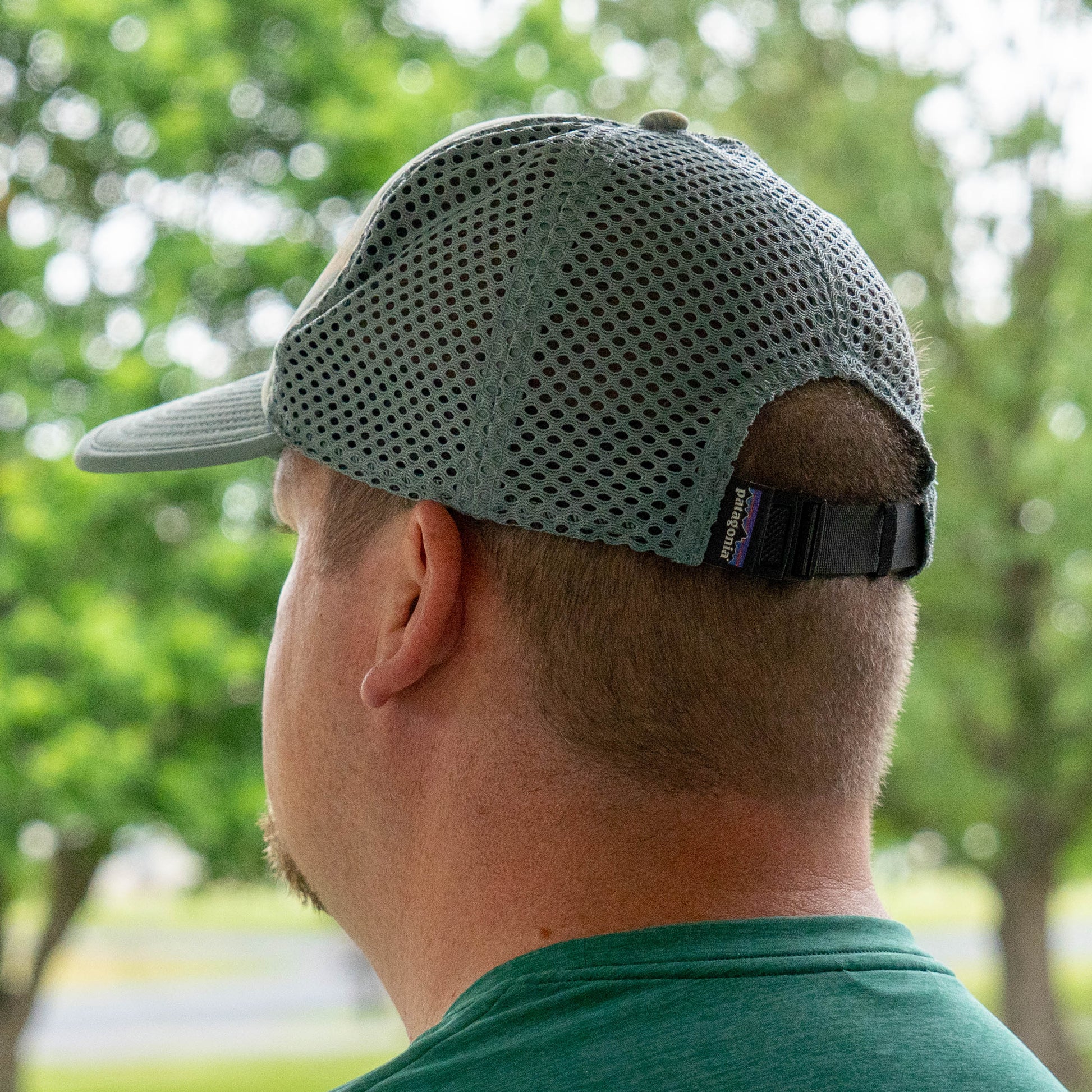 Side view of a man wearing Patagonia Spoonbill trucker hat with breathable mesh panels and adjustable strap, and a Patagonia branded tag