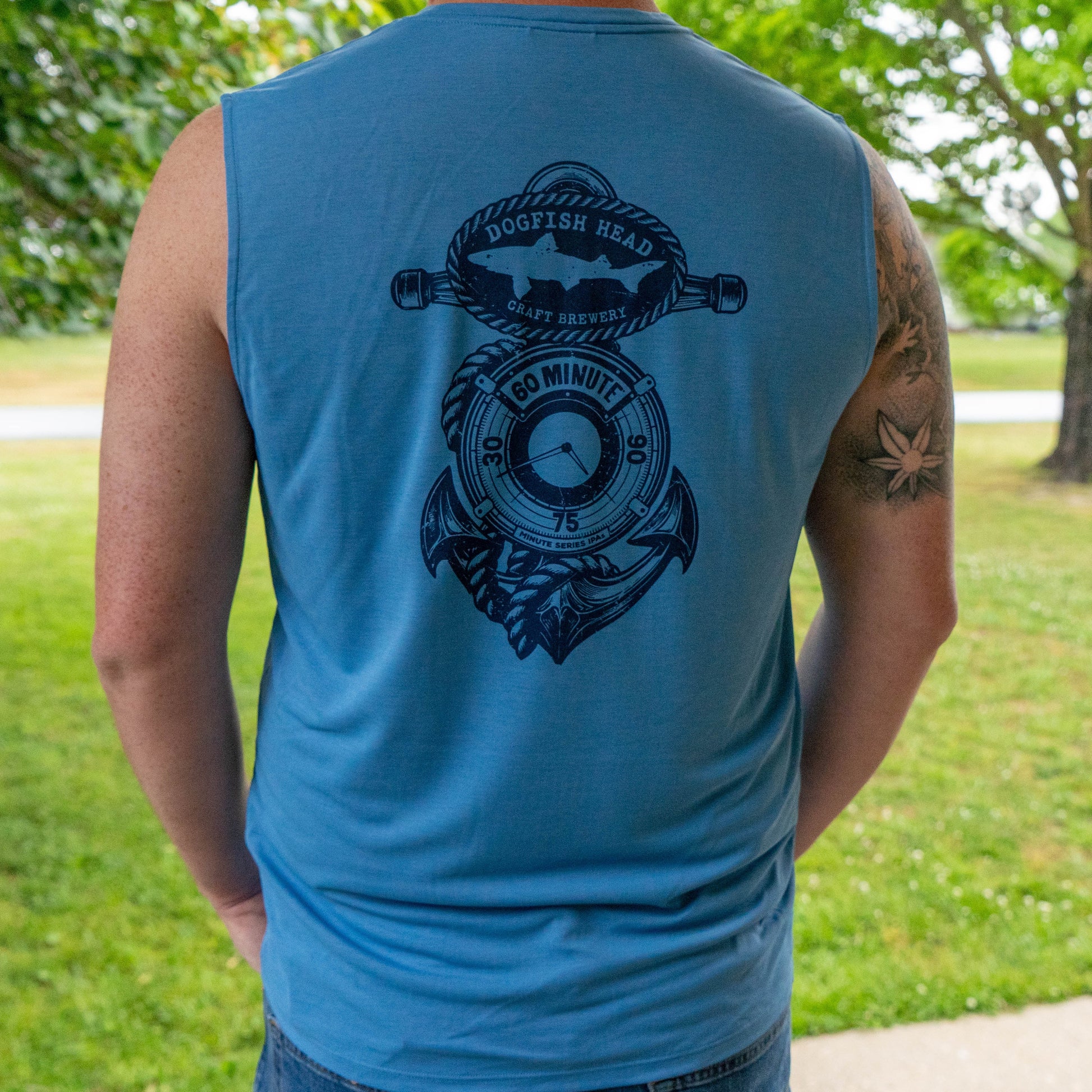 Patagonia sleeveless Cap Cool Daily shirt in blue with Dogfish Head 60 Minute IPA anchor graphic, lightweight performance tank back view outdoors
