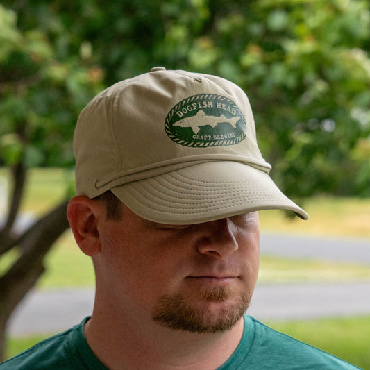 Man wearing Patagonia Spoonbill Merganzer in tan with a Dogfish Head Craft Brewery shark logo