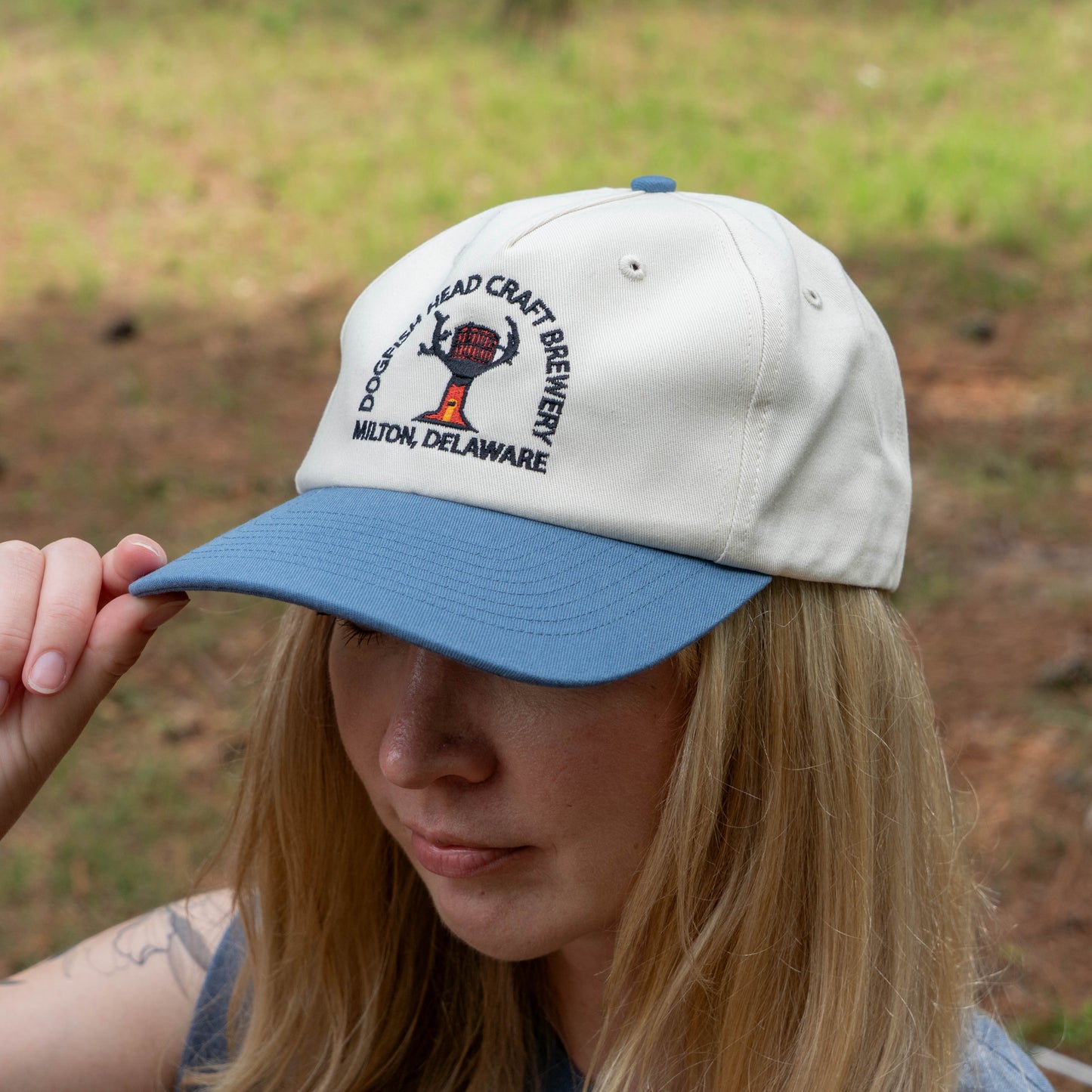 Person wearing a cap with Dogfish Head Craft Brewery logo outdoors