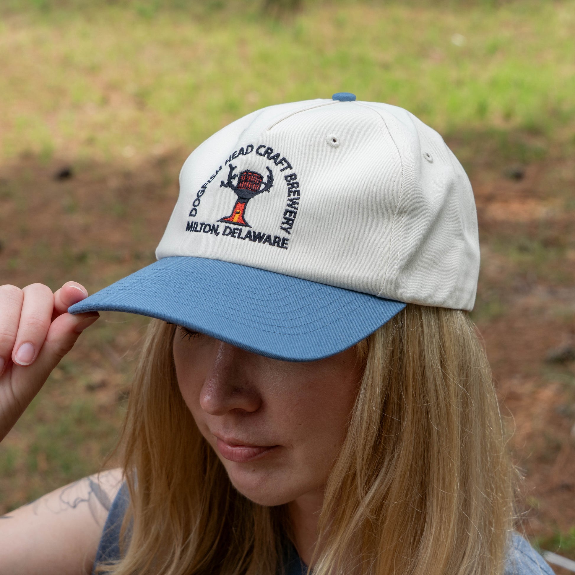 Person wearing a cap with Dogfish Head Craft Brewery logo outdoors