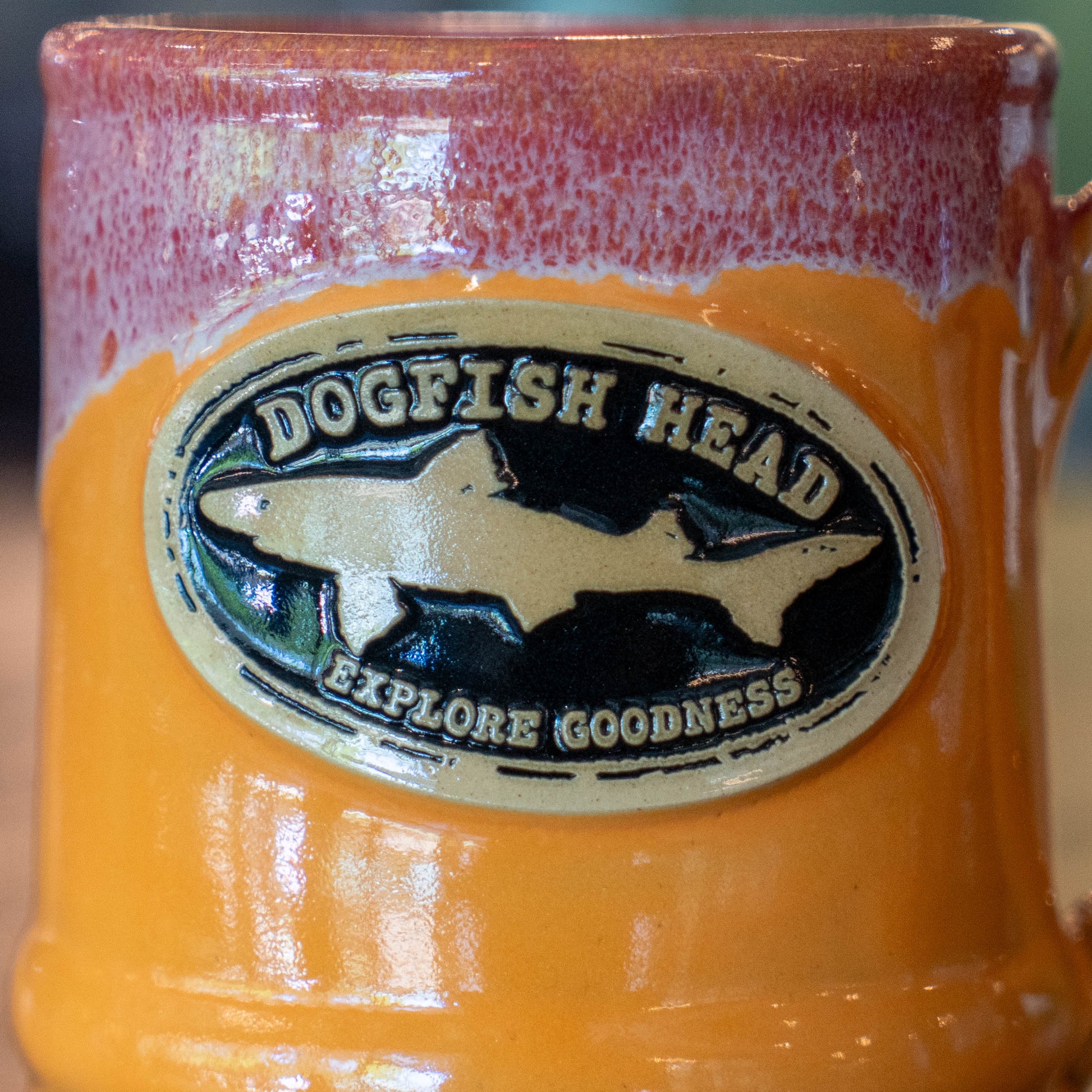 The Tangerine Ramsey Core Ceramic Mug by Deneen Pottery is a 14oz handmade mug with a two-tone glaze and an oval emblem that reads Dogfish Head above a shark silhouette and Explore Goodness below.