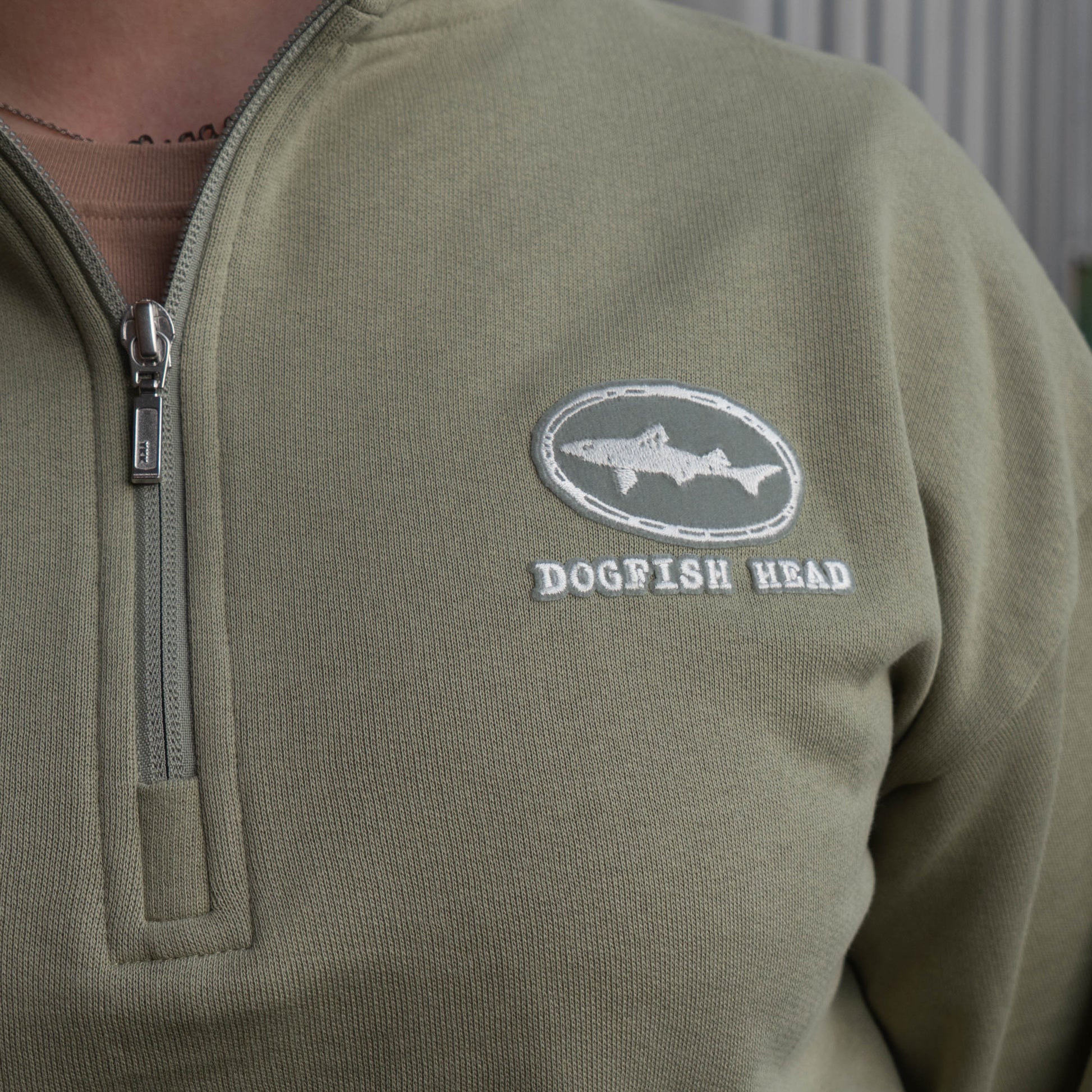 Close up view of Dogfish Head logo designed in Mineral Green on the front left chest of pullover sweatshirt