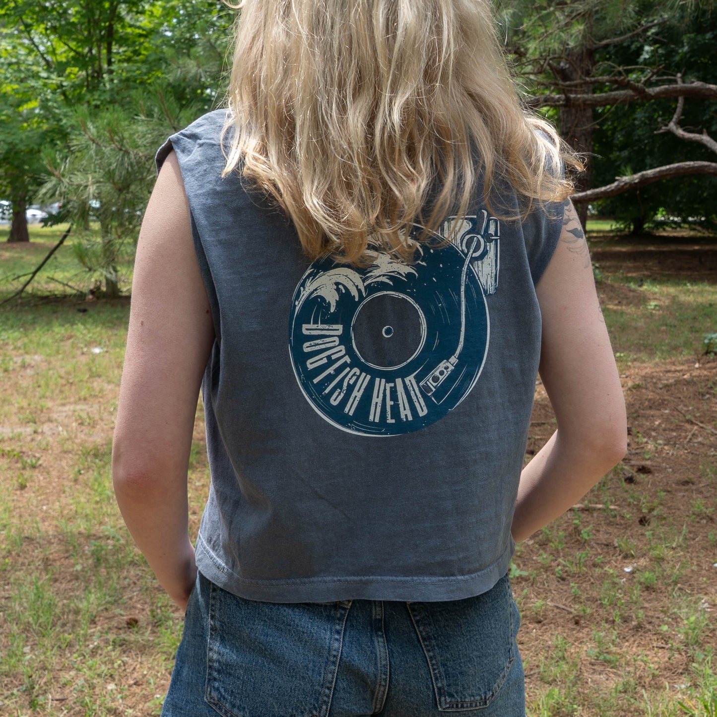 Person wearing a sleeveless shirt with a graphic design outdoors