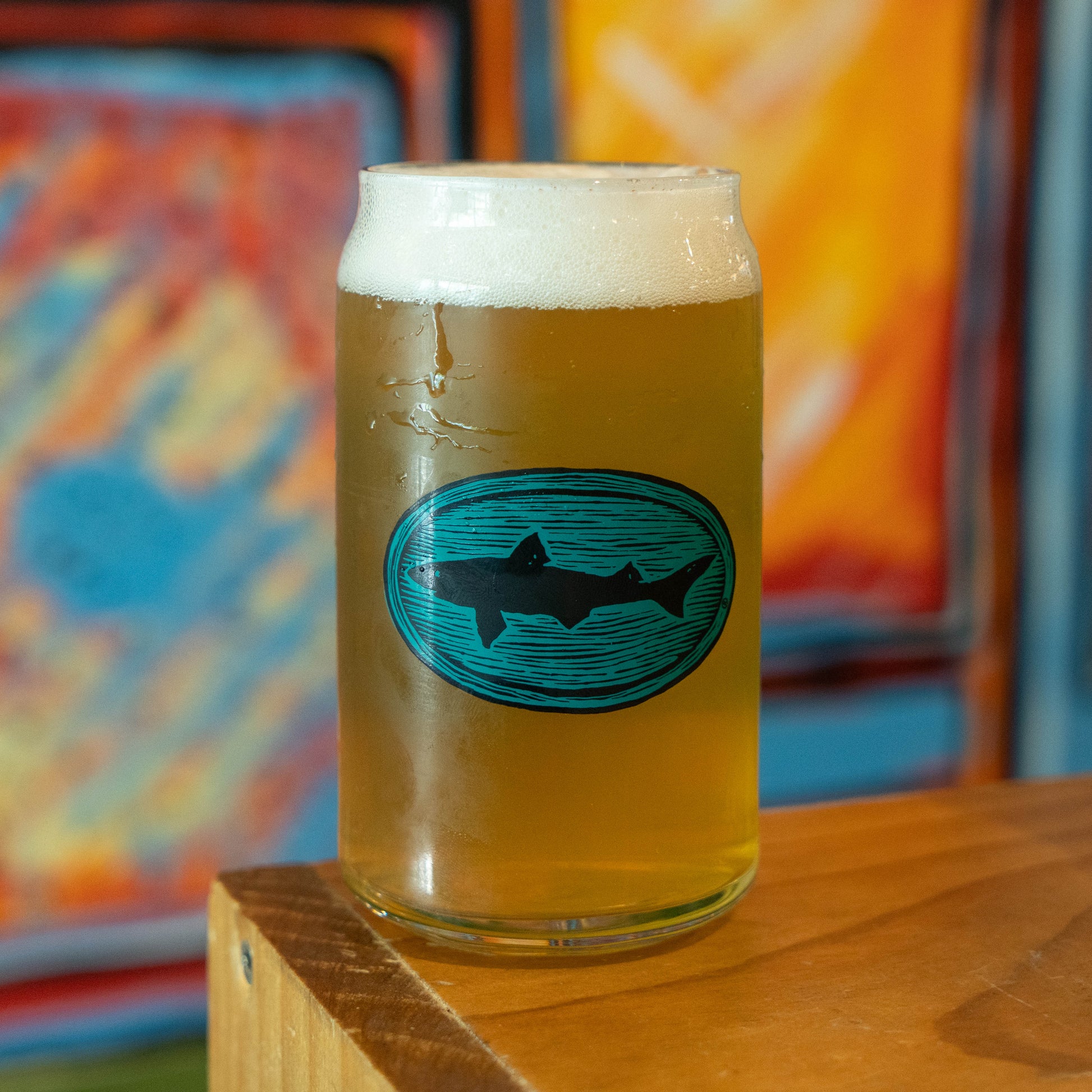 Can glass with a dogfish head logo styled in teal and wood grain