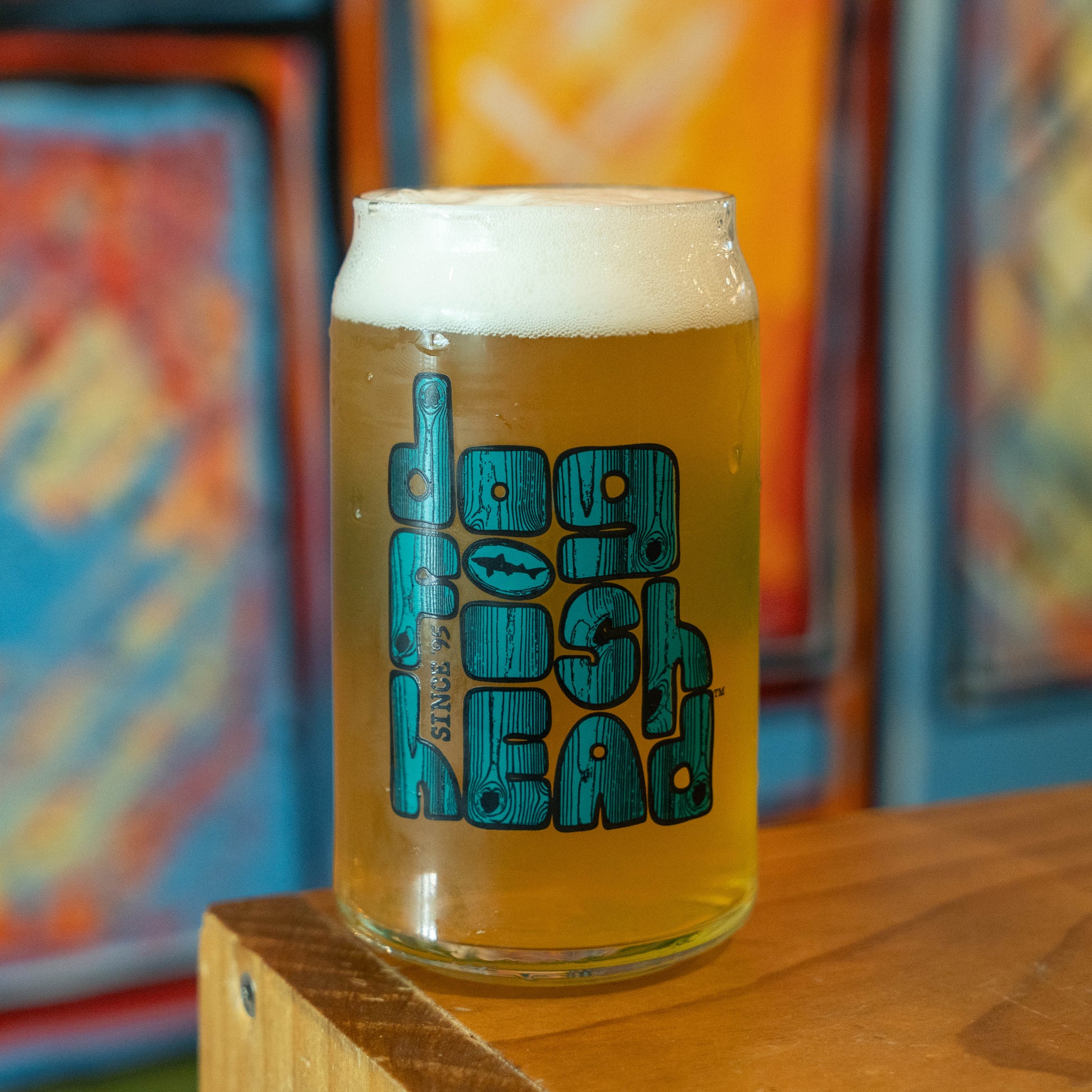 Can glass with a dogfish head logo styled in teal and wood grain