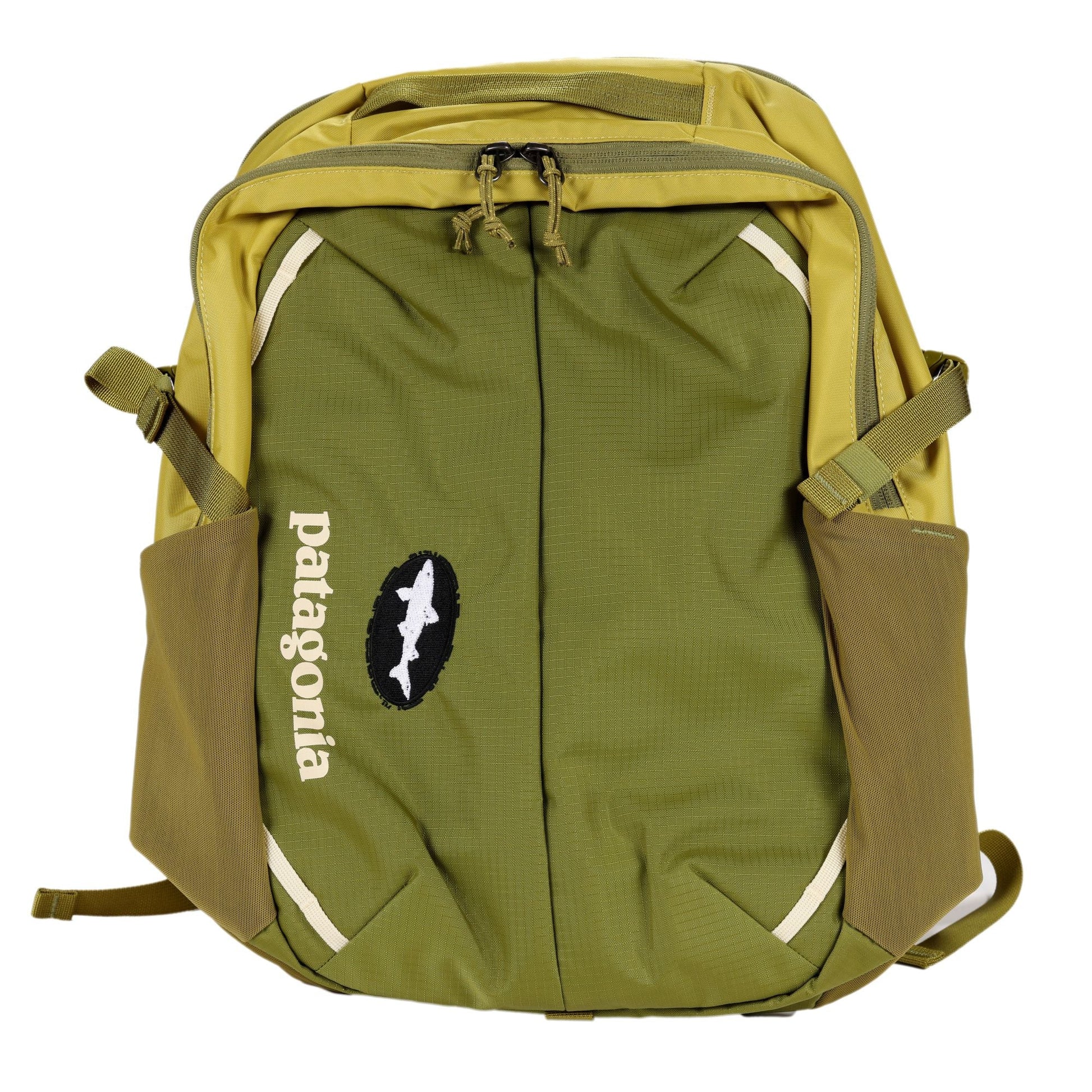 A Patagonia Olive Refugio Day Pack 26L made from recycled polyester, featuring two side pockets, white diagonal accents, and a white fish logo above the brand name. The zipped laptop backpack is laid flat.