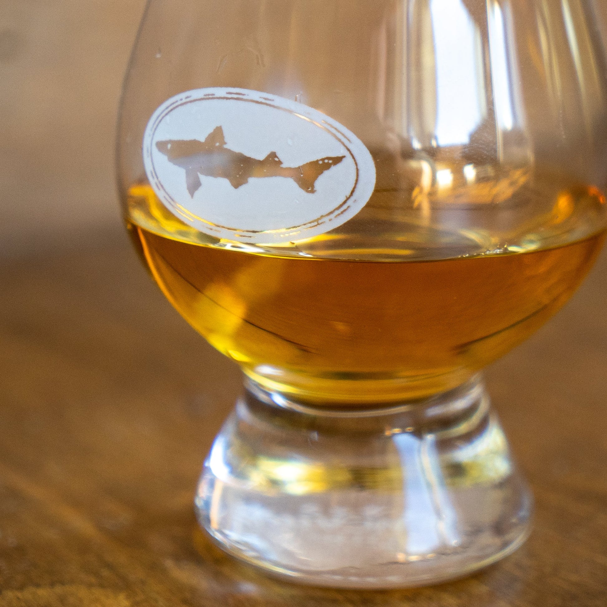 Close‑up of Dogfish Head Glencairn glass featuring shark logo and classic tulip shape for aroma enhancement