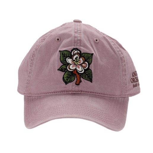 Flower placed in center of front of rose bud blossom hat. Angry Orchard written logo placed on one side of hat. 