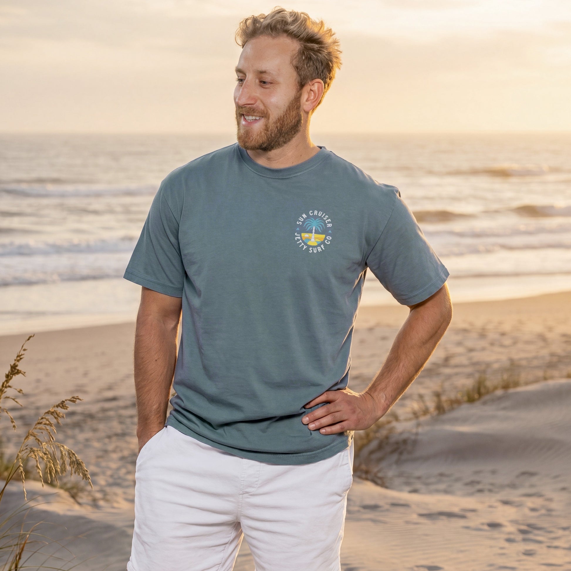 Blue short sleeve tee shirt on person with Sun Cruiser Jetty Surf Co palm tree graphic.
