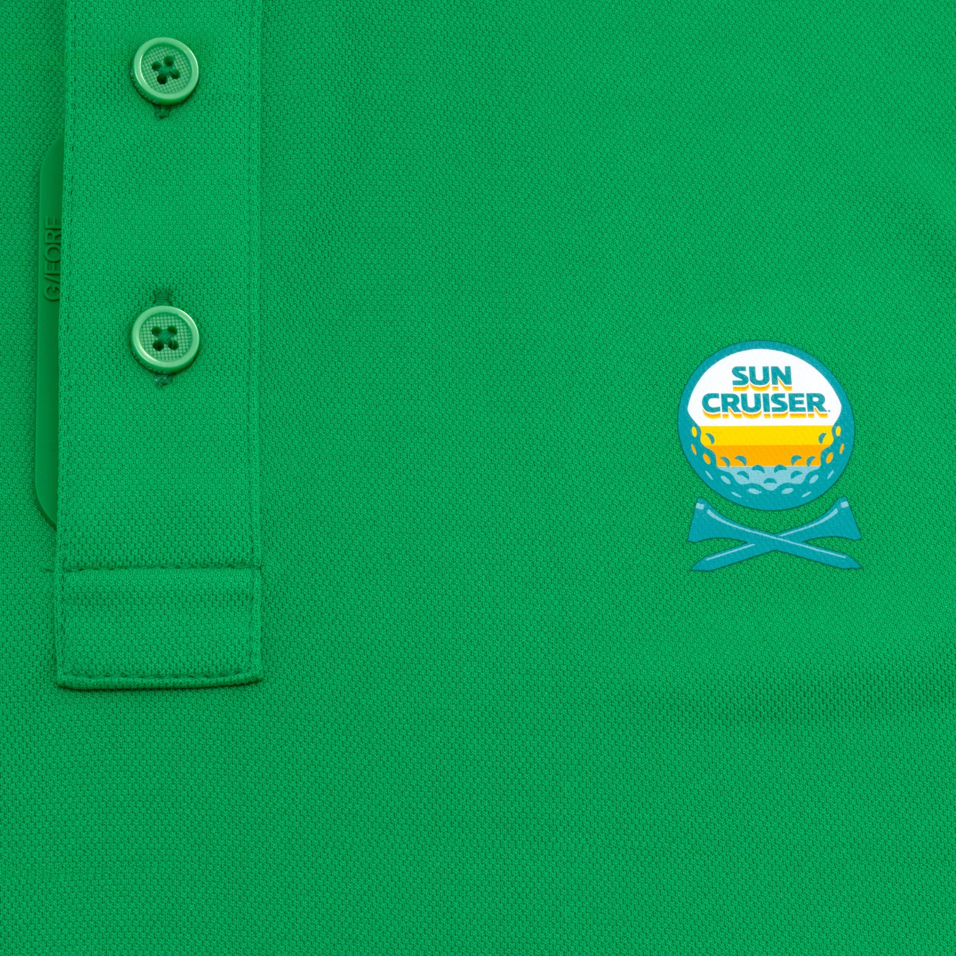 Sun Cruiser x G/FORE green golf polo close-up featuring textured performance fabric, branded button placket, and embroidered chest logo detail