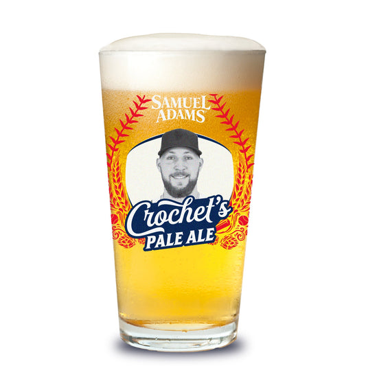 Pint glass of Samuel Adams Crochet's Pale Ale with a person's face on the label.