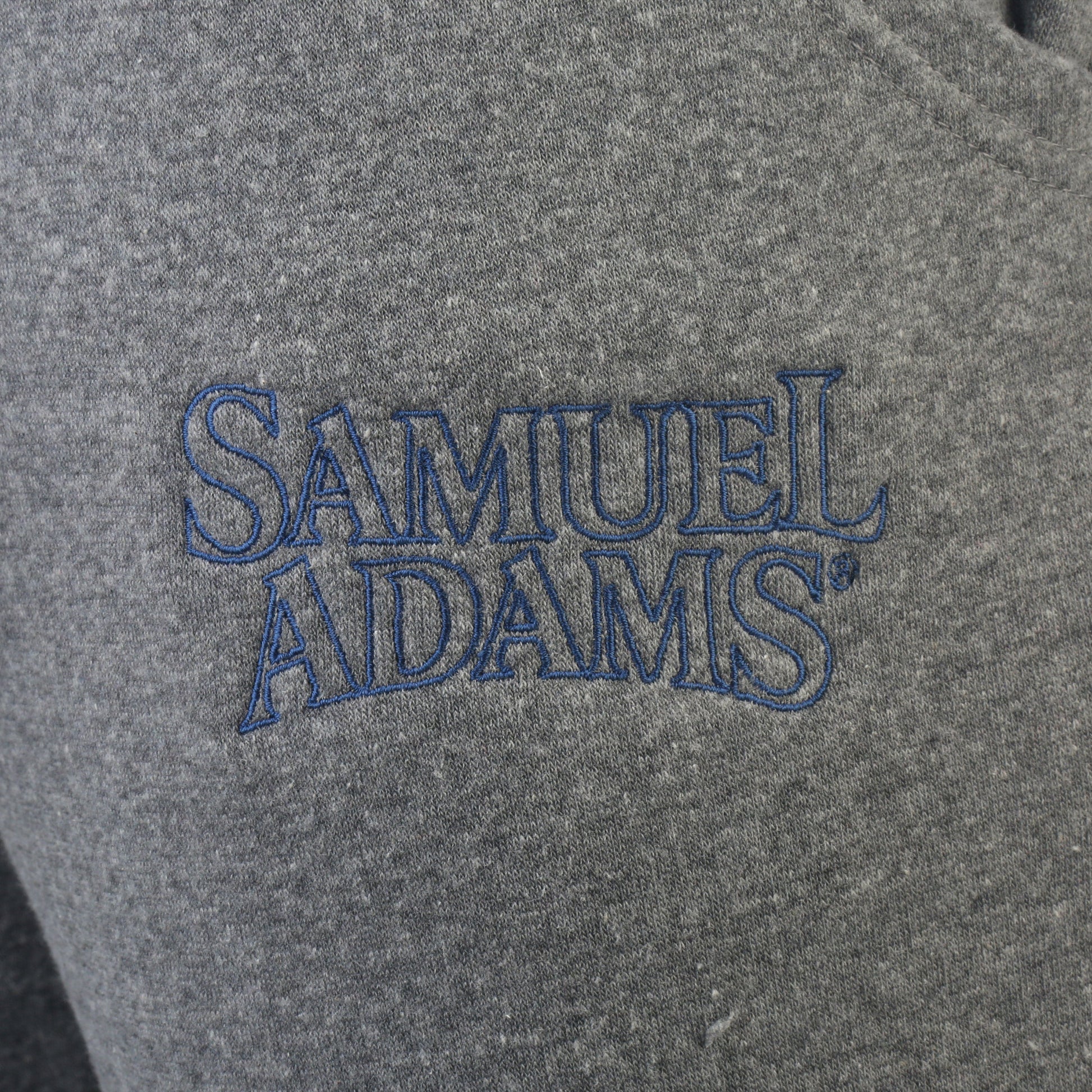 Heather grey jogger with Embroidered Sam Adam Logo, tapered leg, cuffed bottoms, athletic style chunky drawstrings. Close up of embroidered Sam logo pictured here.