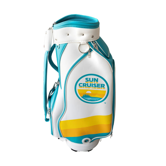 Front view of Sun Cruiser golf bag featuring white body, teal trim, yellow gradient accent, large zippered pocket, and vintage-inspired Sun Cruiser logo