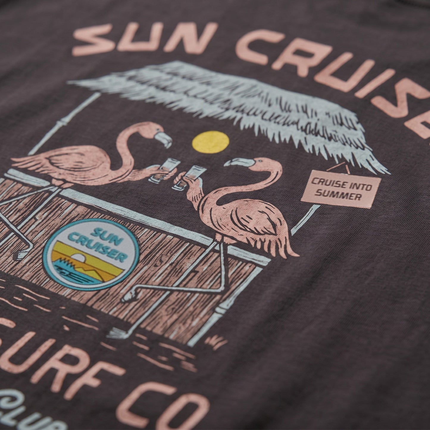 Close up of artwork with two flamingos holding drinks at a tiki bar with Sun Cruiser logo. 