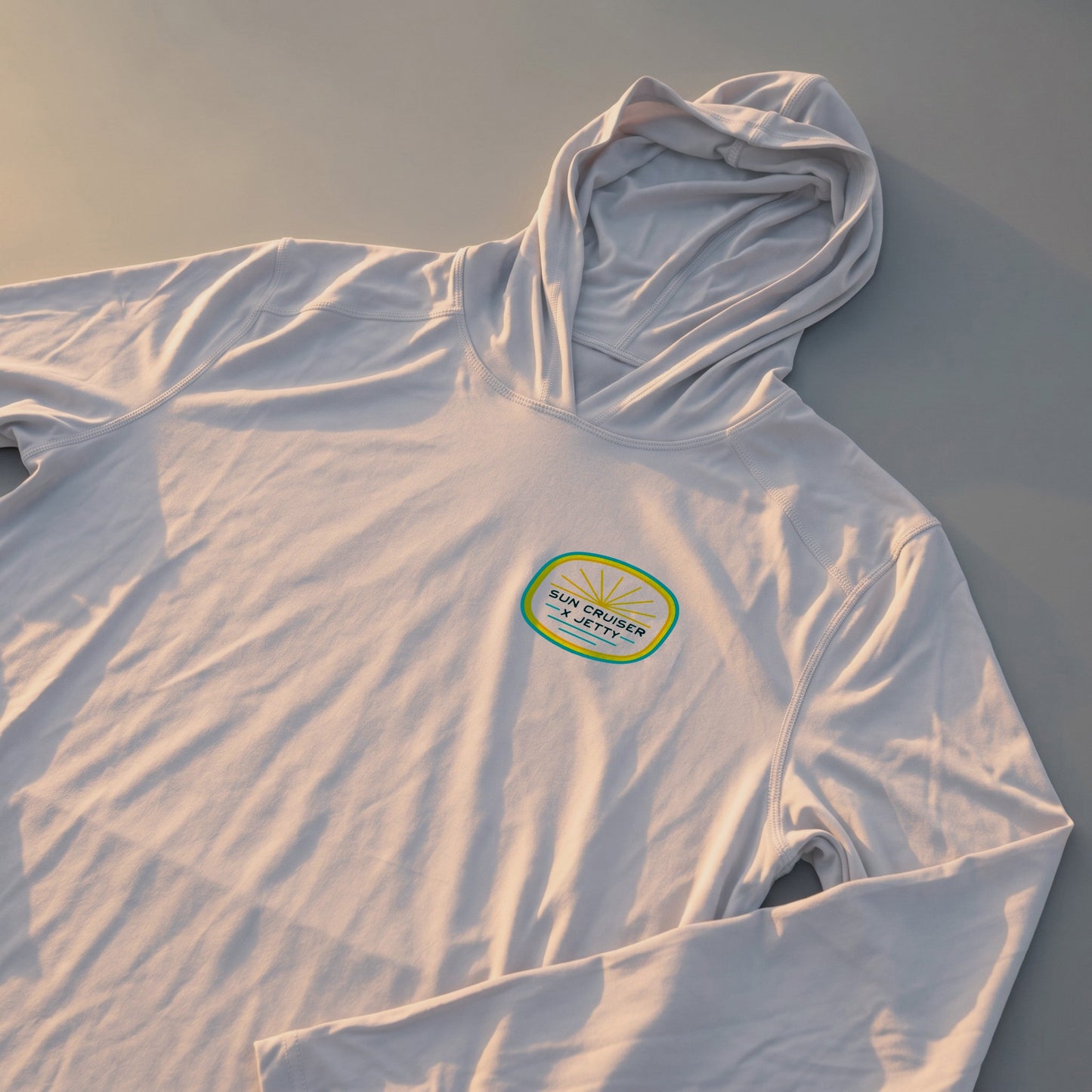 Tan hoodie with Sun Cruise x Jetty logo 