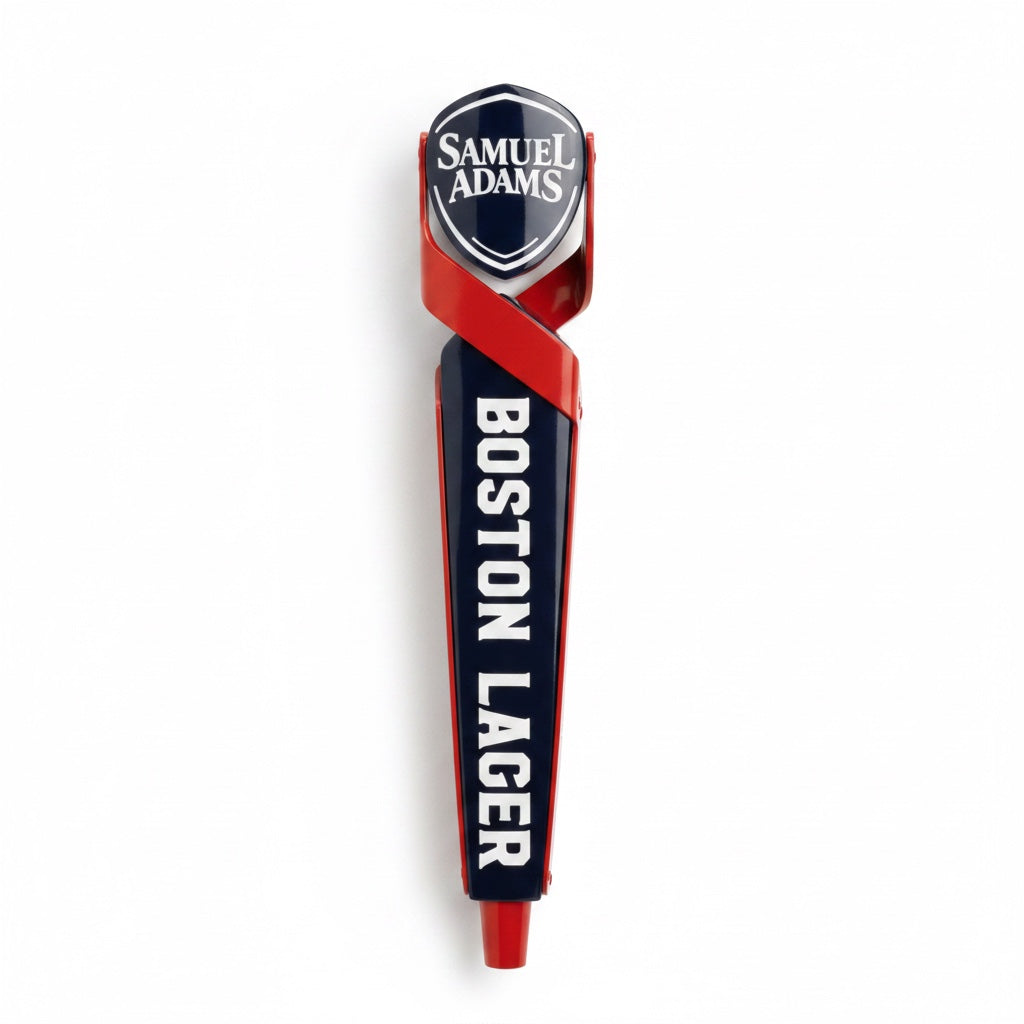 A tap handle with the Sam Adams logo written in white against a blue shield shaped piece. The shield is being held by two red shapes that cross and continue down the tap handle.  Boston Lager is written vertically in white across the blue body of the tap handle. There is a red   cylindrical shape at the bottom. 