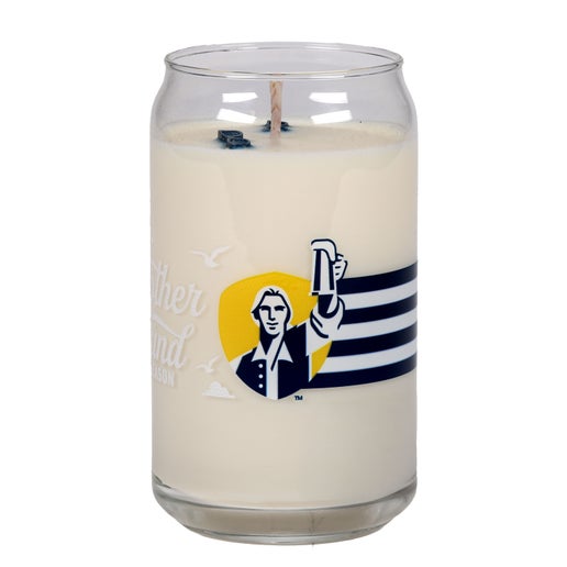 Candle with Black, white, and yellow Samuel Adams logo and a light house design. Black and white stripes wrap the middle of the candle connecting to a Samuel Adams hoist a beer logo to form a near 360 design.