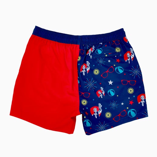 Split design swim trunks. One half is dark blue with red, white, and blue fireworks, stars, beachballs, and Samuel Adams logo on it. The other half is solid red with a white samuel adams logo on bottom of the trunk leg