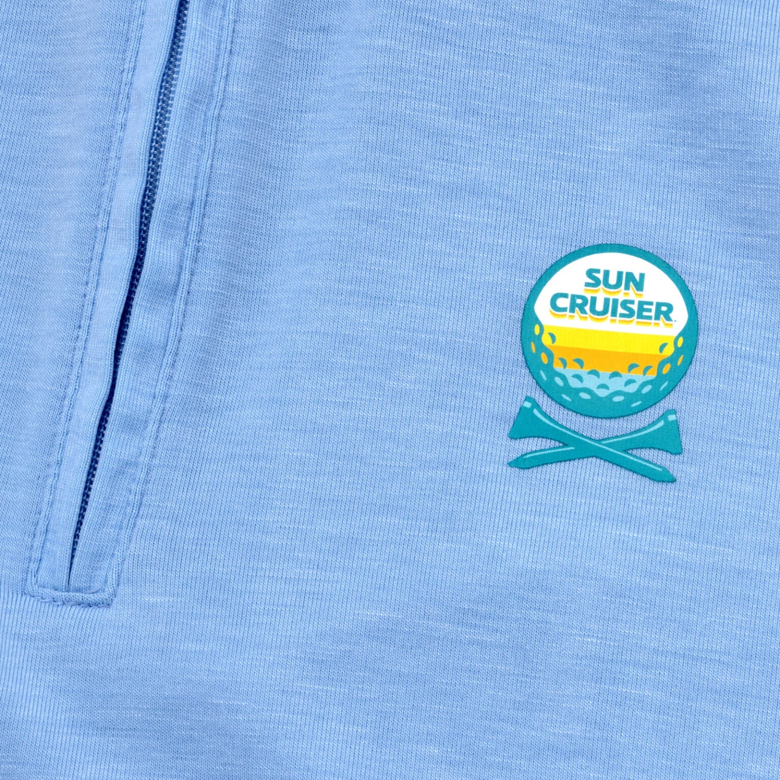 Sun cruiser golf ball and cross tee logo on  a baby blue GFORE quarter zip 