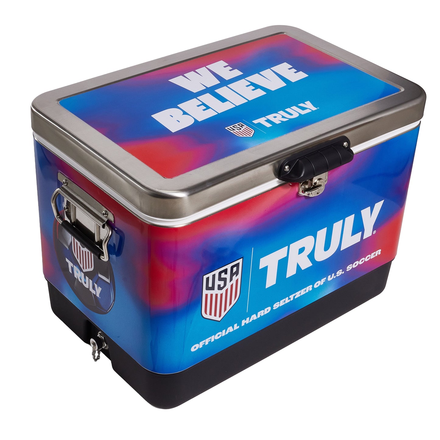 Angled view of the Truly USA metal cooler highlighting the colorful blue and red gradient exterior, front latch, side handles, and “WE BELIEVE” text on the lid. The design features bold Truly branding and a shield‑style USA graphic on the front.