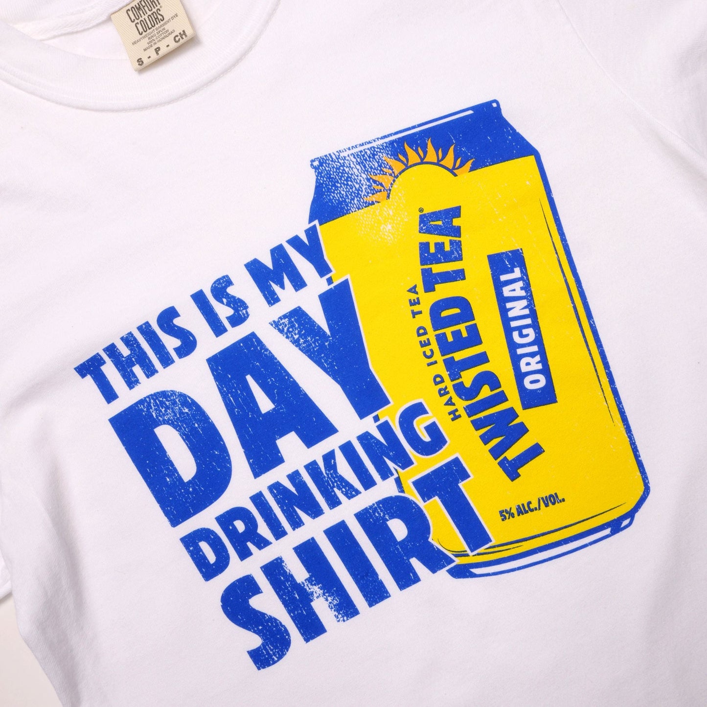 White t-shirt with a graphic of a Twisted Tea can and text 'This is my day drinking shirt'.