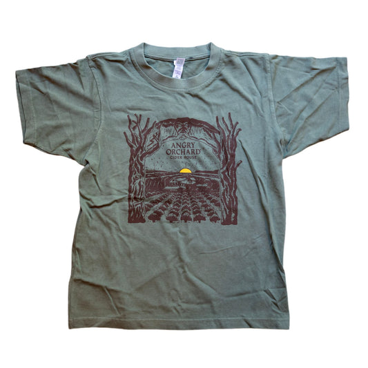 Unisex Green Angry Orchard Treehouse Short Sleeve Shirt. Centered on the front of the shirt is a dark brown hand drawn like image of an orchard with a small yellow sun setting on the horizon. Bordering the sides of this image are two trees that form an arch over the top border imagery. In the center of this imagery reads "Angry Orchard, Cider House" in the classic angry orchard font.
