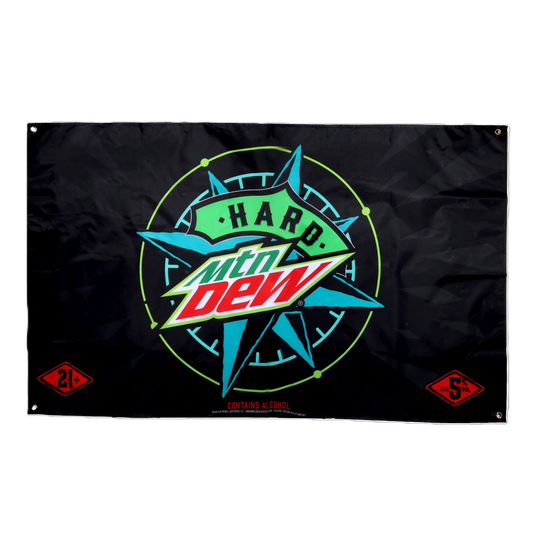 Black rectangular flag for "Hard MTN DEW." The center features the "MTN DEW" logo in green and red with "HARD" written in green above it. This is set against a teal starburst or compass-like design with a thin neon green circle around it. In the bottom left corner, there's a red diamond shape with "21+" in white. In the bottom right corner, there's a red diamond shape with "5% ALC/VOL" in white. Below the main design, small white text reads "CONTAINS ALCOHOL." There are metal grommets in each corner.