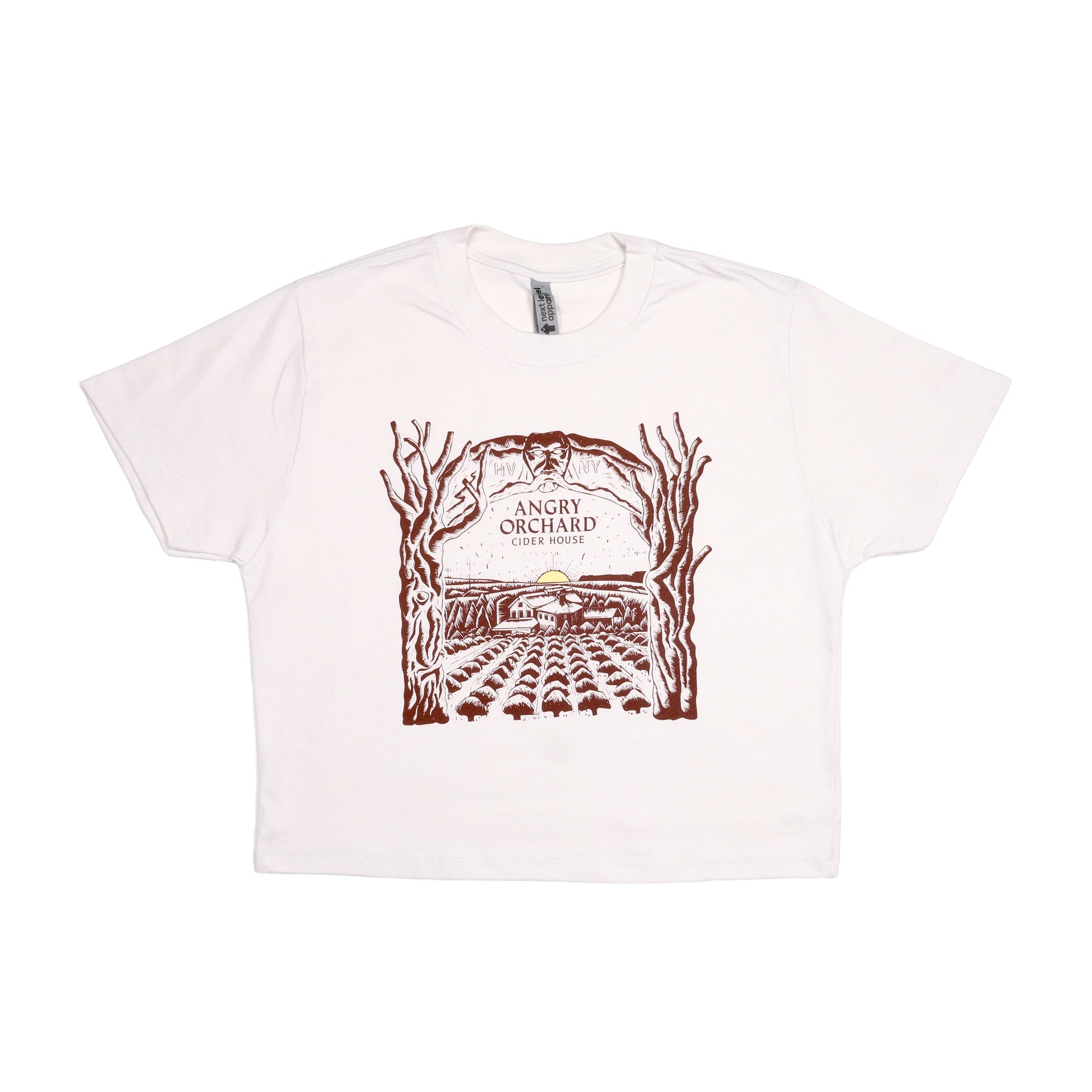 Angry Orchard Cider House design in dark red print on a white bone short sleeve T-shirt. The design is a hand drawn like image of the cider house sitting in the orchard, with a small yellow sun setting on the horizon. Bordering the sides of this image are two trees that form an arch over the top border imagery. In the center of this imagery reads "Angry Orchard, Cider House" in the classic angry orchard font.