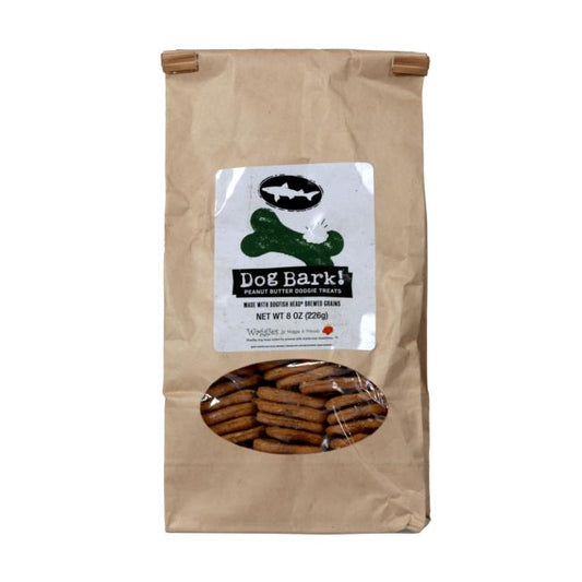 A brown paper bag of Waggies Peanut Butter Dog Treats by Waggies by Maggie & Friends Inc, made in Wilmington, DE, with a clear window showing the treats and a white label with a green bone graphic and product details.