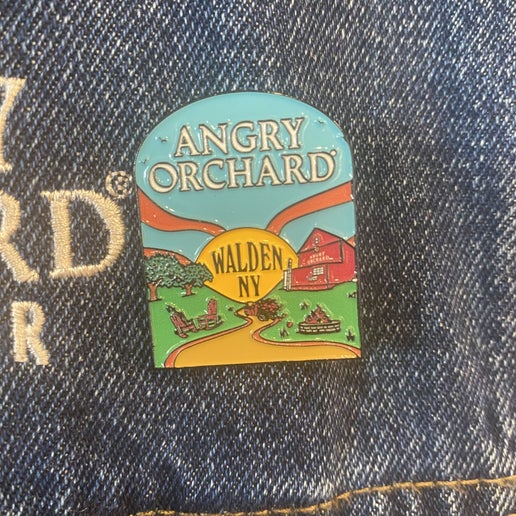 Pin features "Angry Orchard" written at the top of pin and Walden, NY in the center. Design on pin is Angry Orchard orchard in Walden.