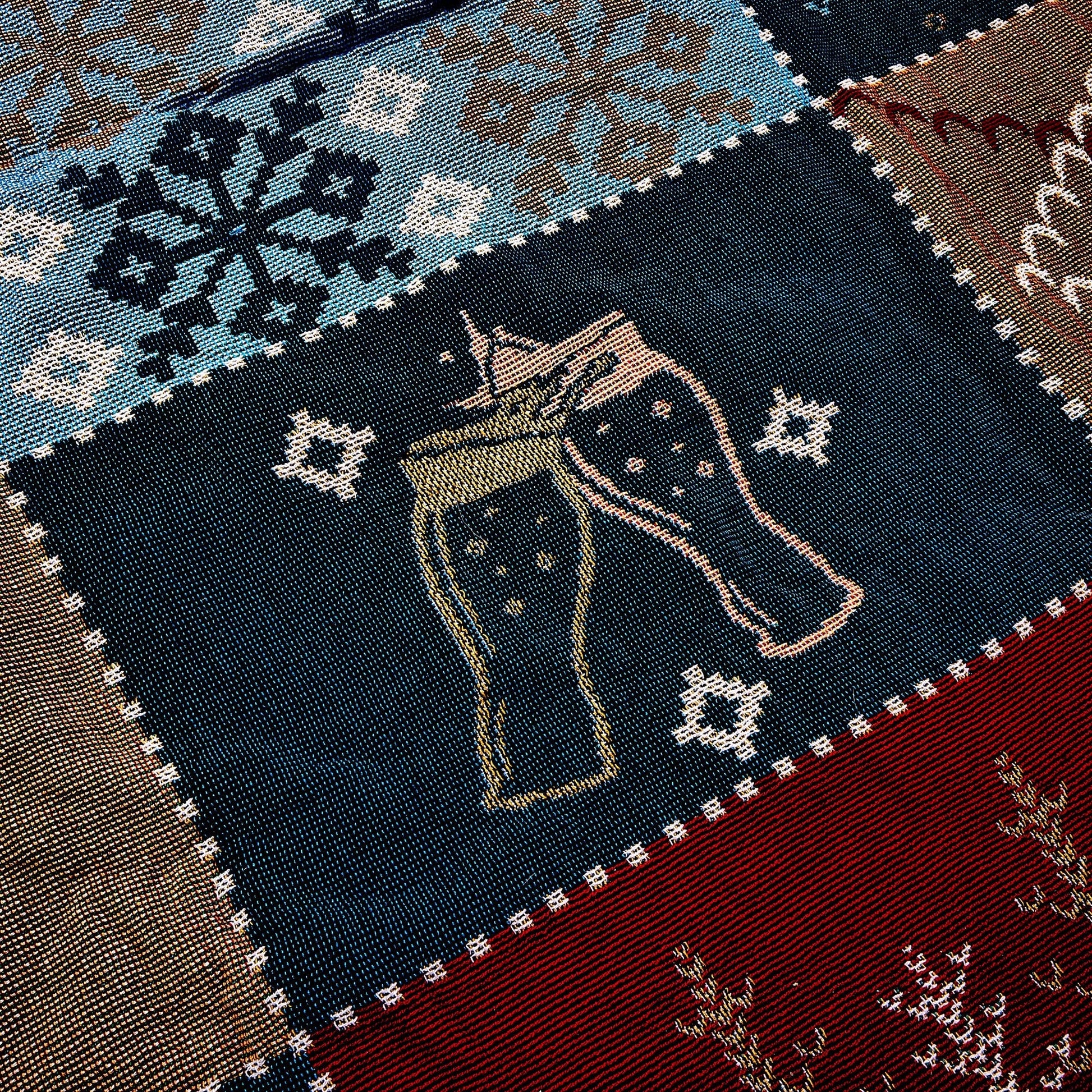 Close up of navy square with tan pint class cheers design on blanket