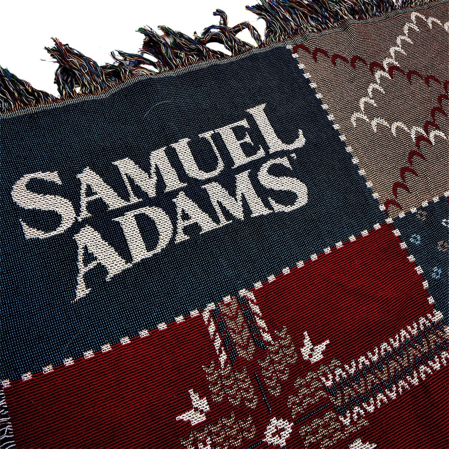 Close up of Navy square on Winter Tapestry Blanket 62 x 54. Navy square has a Samuel Adams logo
