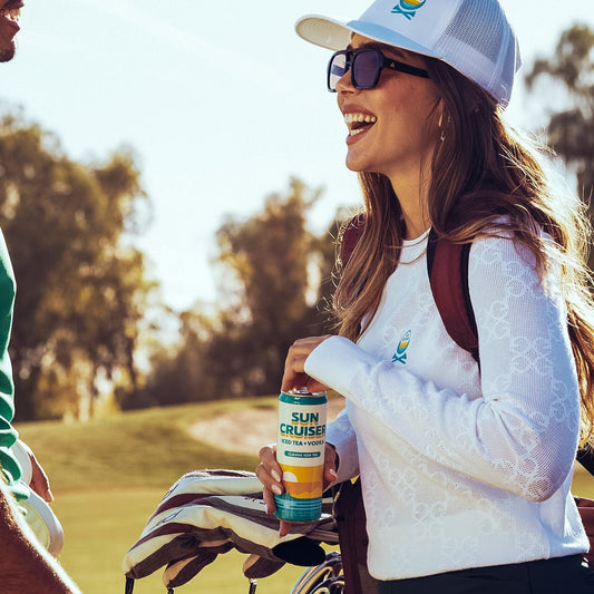 Woman holding a Sun Cruiser drink on a golf course