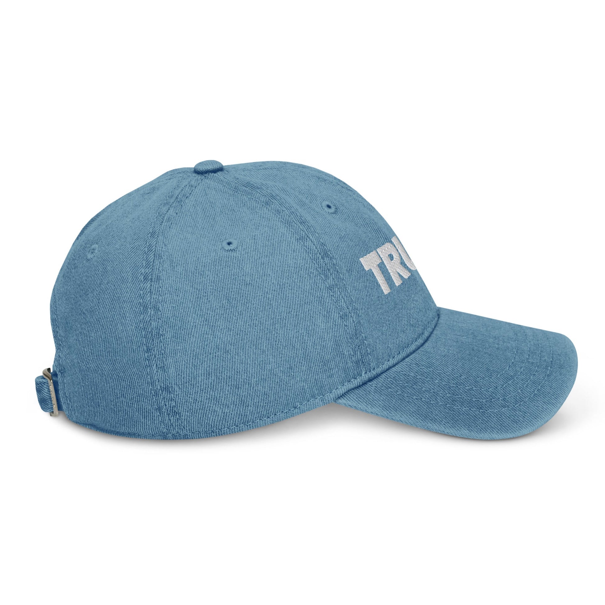 Side view of  a light blue denim dad hat with a white Truly Logo front and center 