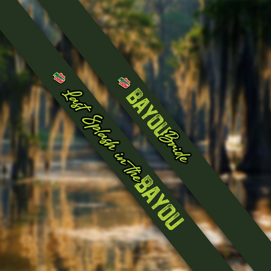 Green sash with 'Bayou Bride' text and logo against a blurred natural background